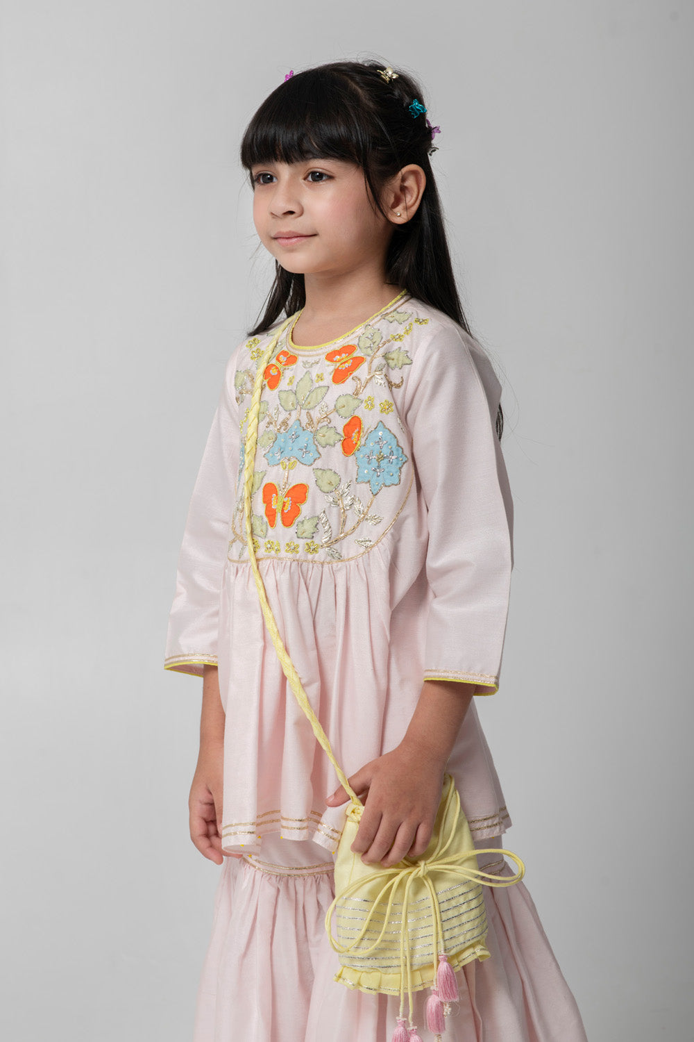 Pastel pink sharara with patchwork intricate embroidery. Cute neon potli added