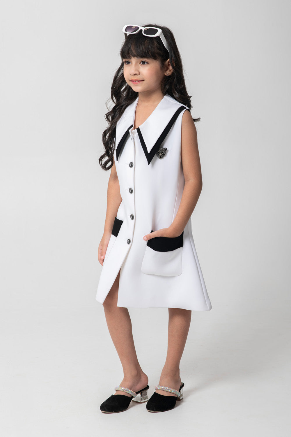 Black and white formal blazer dresses with embellished buttons and brooch.