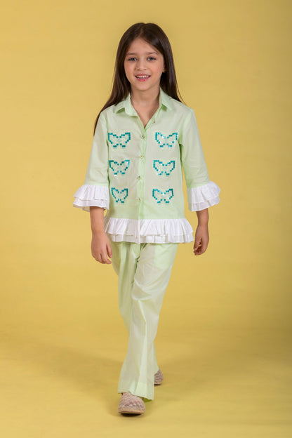 A MINT CO-ORD SET FEATURING A BUTTERFLY-EMBROIDERED SHIRT AND MATCHING WIDE-LEG PANTS.